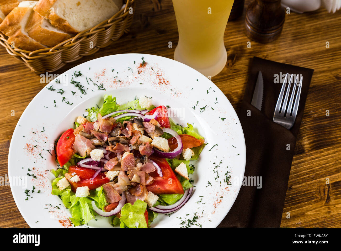 meat salad with spices and vegetables with light beer on on wooden table Stock Photo