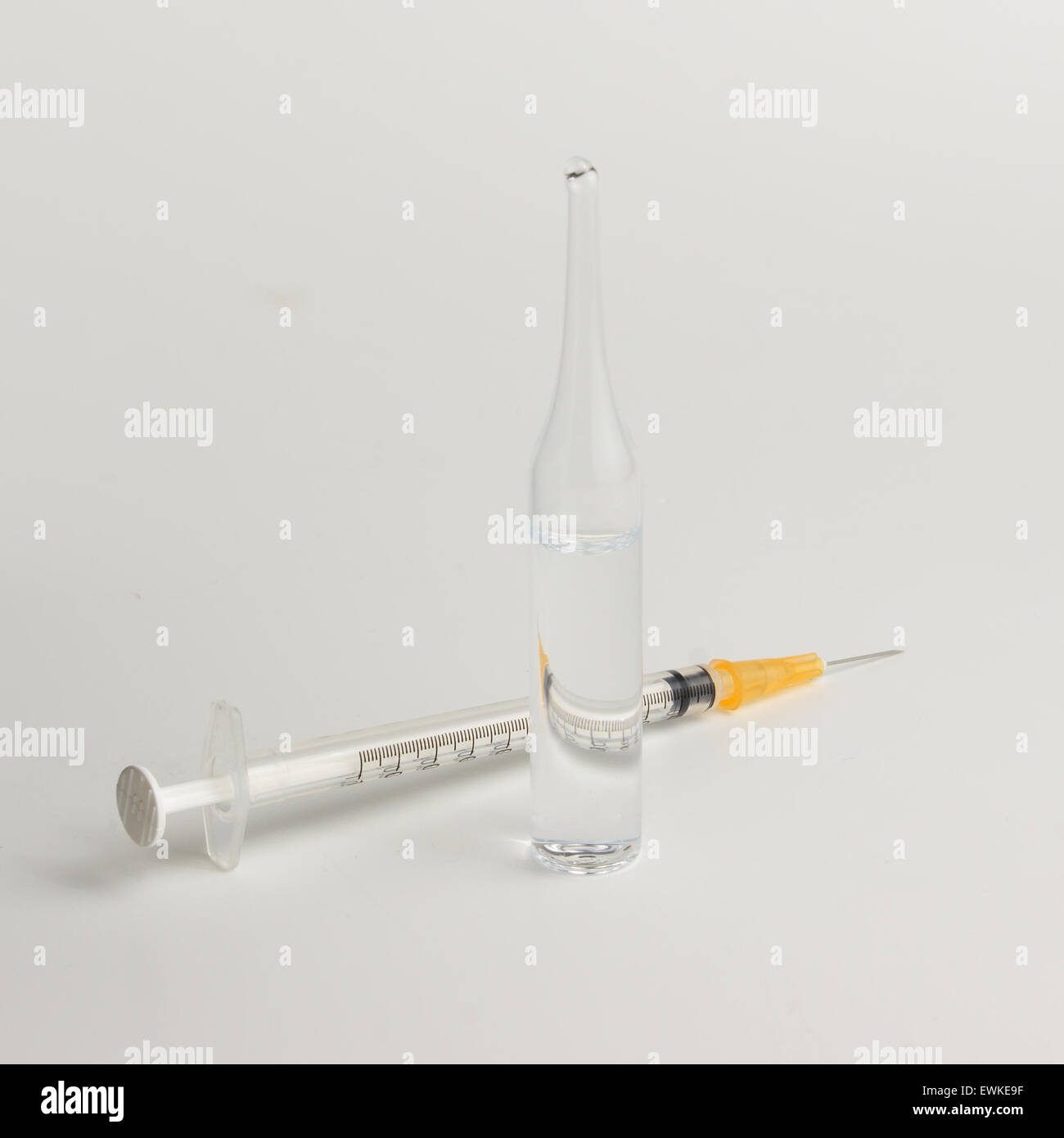 a syringe with a sharp needle and ampule with a drug on a white background Stock Photo