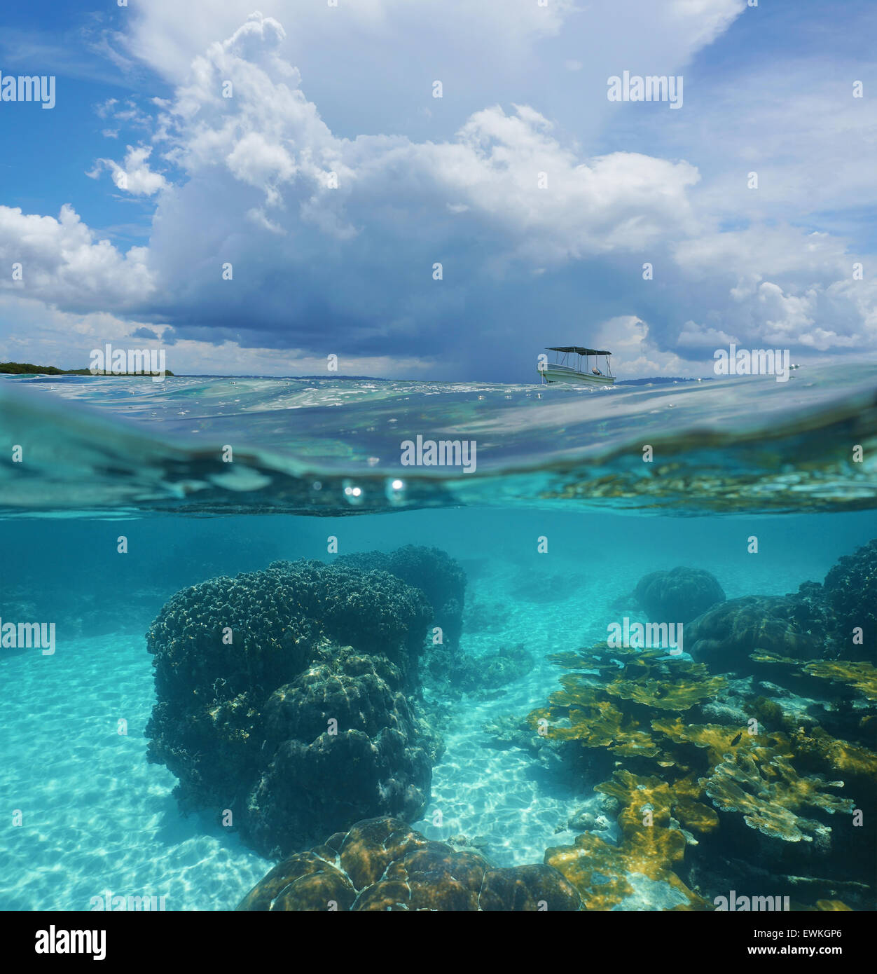 Split image with corals underwater and threatening cloud with a boat above waterline, Caribbean sea, Panama Stock Photo