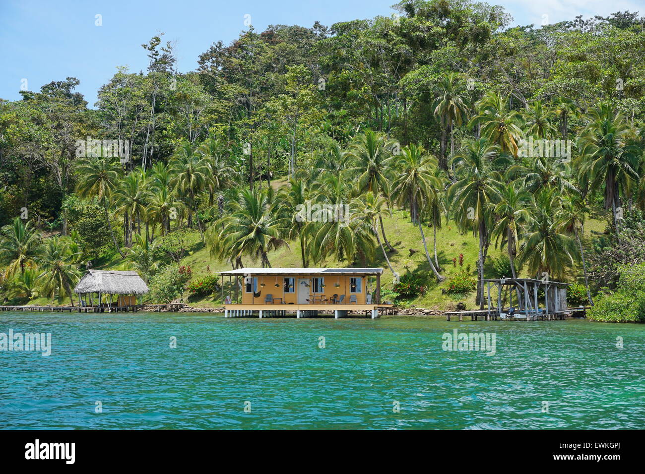 Tropical oceanfront property in Panama with lush vegetation and house with hut over water
