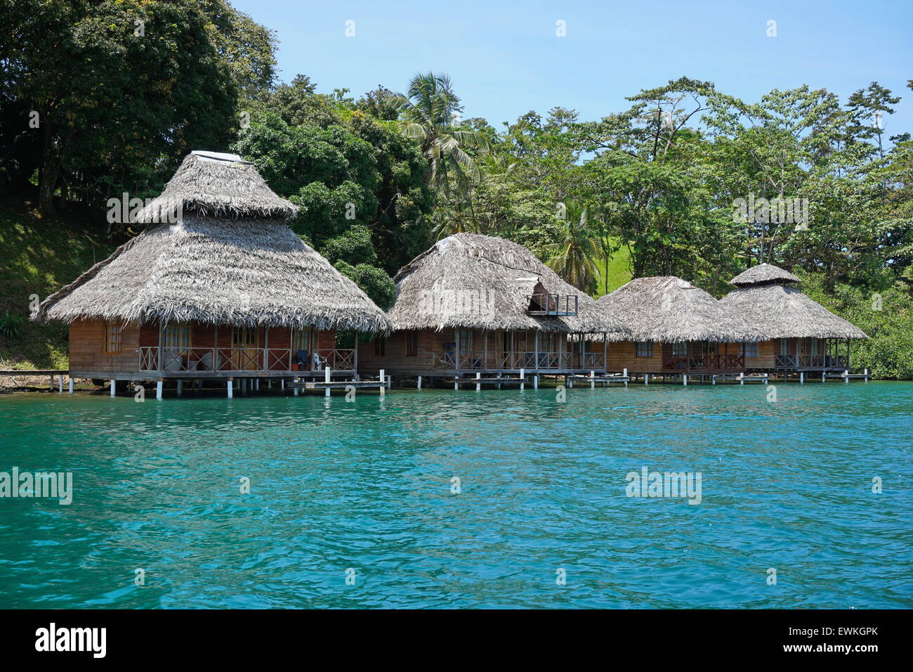 Tropical eco resort with thatched bungalows over water of the Caribbean sea in Panama, Bocas del Toro, Central America Stock Photo