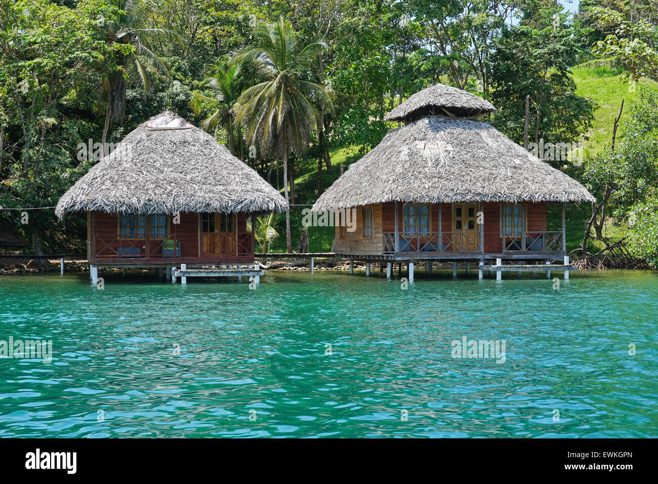 Tropical wooden bungalows with thatched roof over the water, Caribbean sea, Bocas del Toro, Central America, Panama Stock Photo