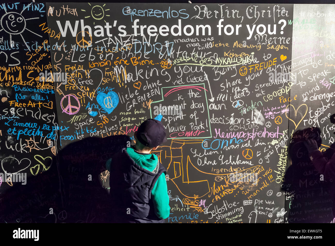 Children write on a chalk board celebrating 25 years since the fall of the Berlin Wall at Mauerpark, Berlin, Germany. Stock Photo
