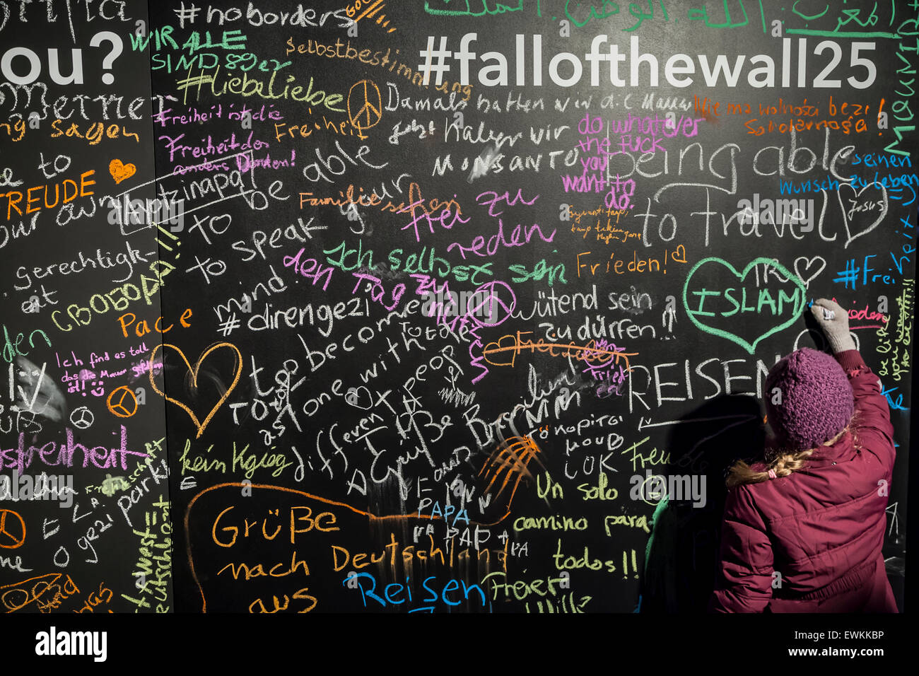 A child writes on a chalk board celebrating the 25 years since the fall of the Berlin Wall at Mauerpark, Berlin, Germany. Stock Photo