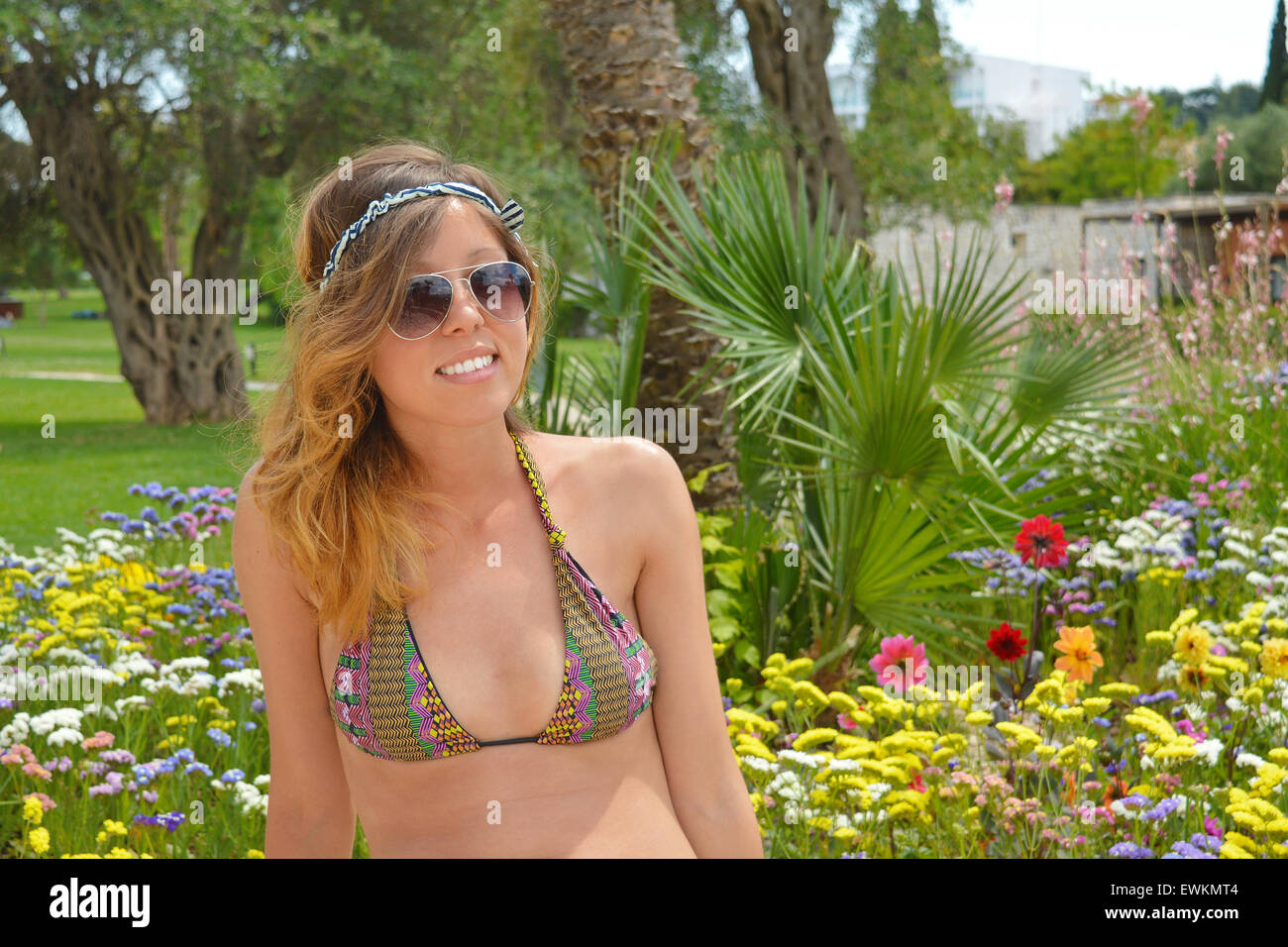 Young girl posing in colorful garden in bikini Stock Photo
