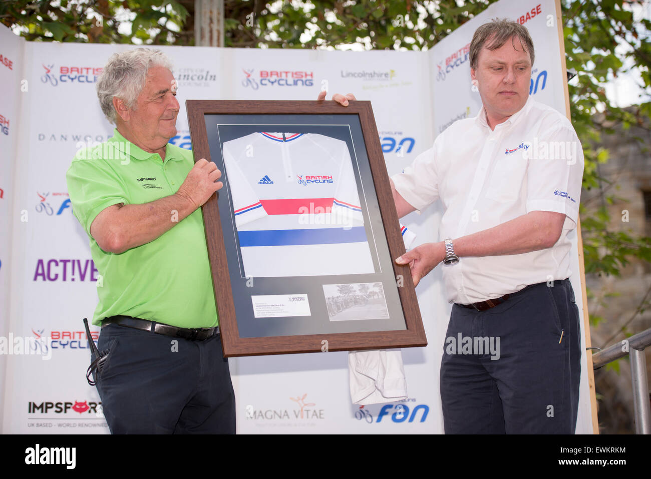 Lincoln, UK. 28th June, 2015. Race organiser Ian Emmerson OBE (left) is presented with a framed British Champions jersey after the British Cycling Road Race Championships at Lincoln, United Kingdom on 28 June 2015. This was the final time that Emmerson will organise the event, having done so on fifty occasions. Credit:  Andrew Peat/Alamy Live News Stock Photo