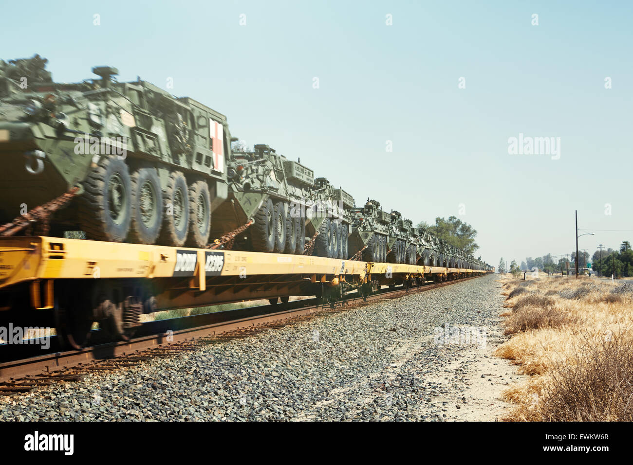 An endless cargo of tanks on a train pulled down tracks in an empty dry landscape. Stock Photo