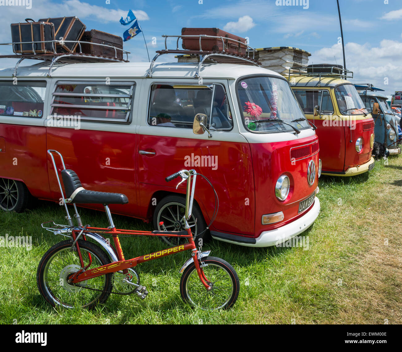 Classic red Volkswagen campervan at Volksfest Bristol with Raleigh Chopper standing next to it. Stock Photo
