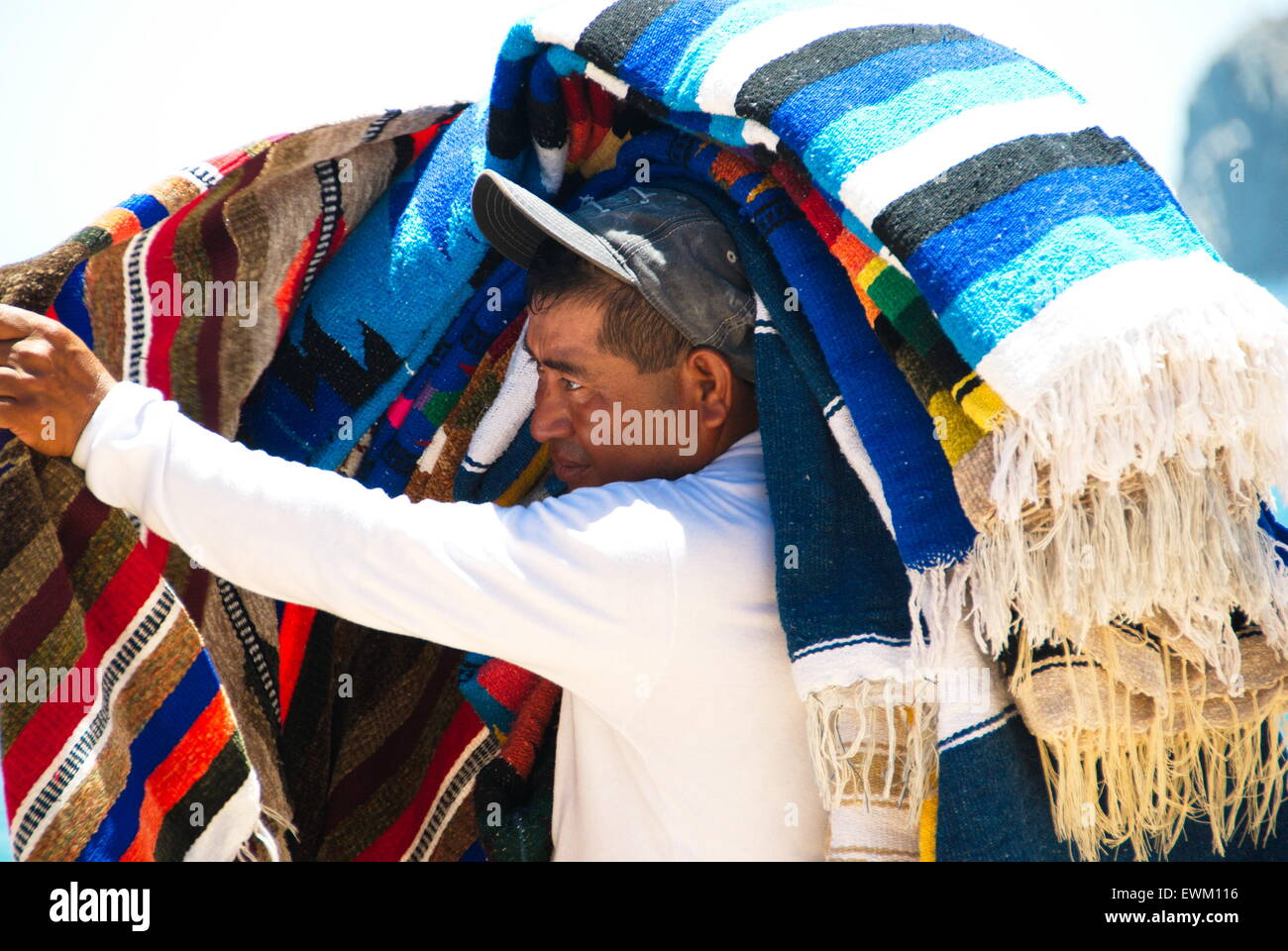 Local man selling handmade blankets on beach to customers Stock Photo
