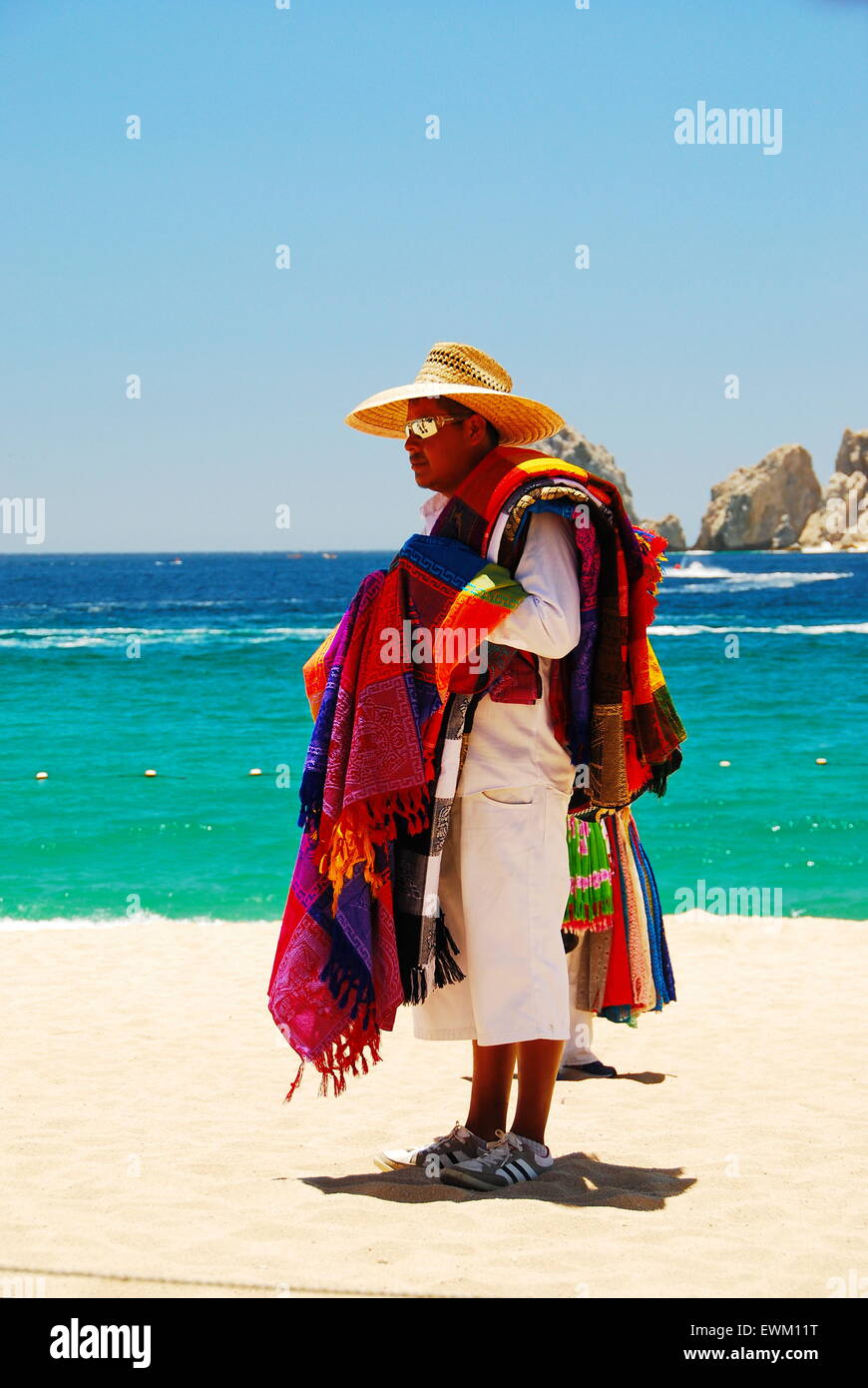 Local man selling colorful linens on the beach in Cabo San Lucas, Mexico Stock Photo