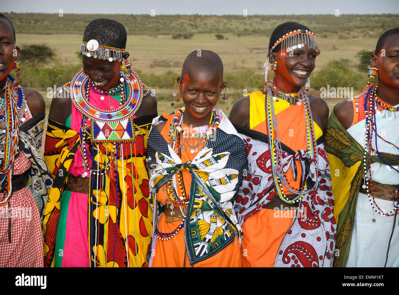 Masai women wearing colorful traditional dress, singing, laughing and smiling in a village near the Masai Mara, Kenya, Africa Stock Photo
