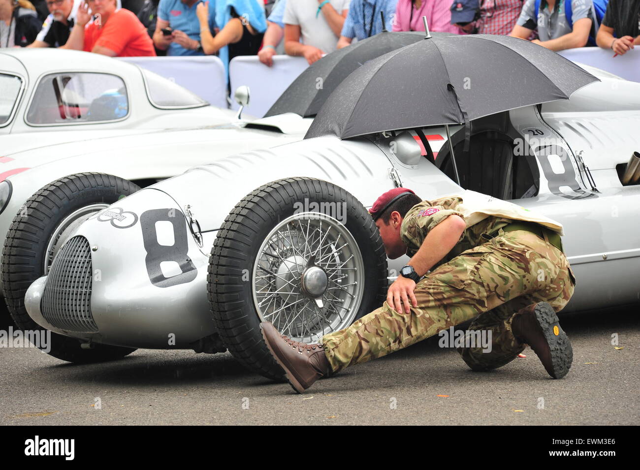 A soldier admires an Auto Union racing car at the Goodwood Festival of Speed. Racing drivers, celebrities and thousands of members of the public attended the Goodwood Festival of Speed to see modern and old racing cars and bikes in action. Stock Photo
