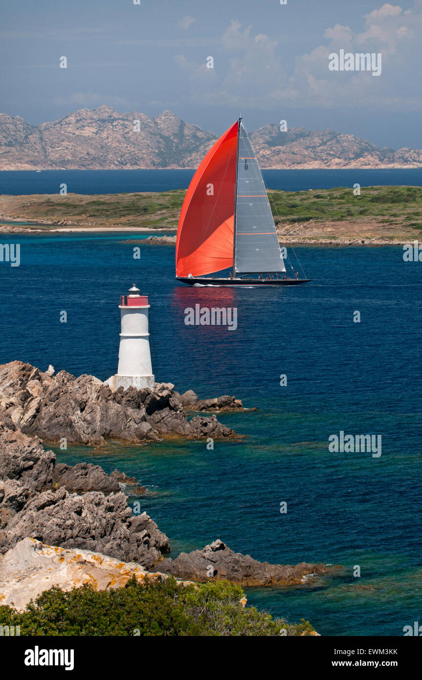 Emerald coast,Sardinia,Italy, 06/2013.Red sail yacht and lighthouse on the coast near Porto Cervo,Costa Smeralda Stock Photo