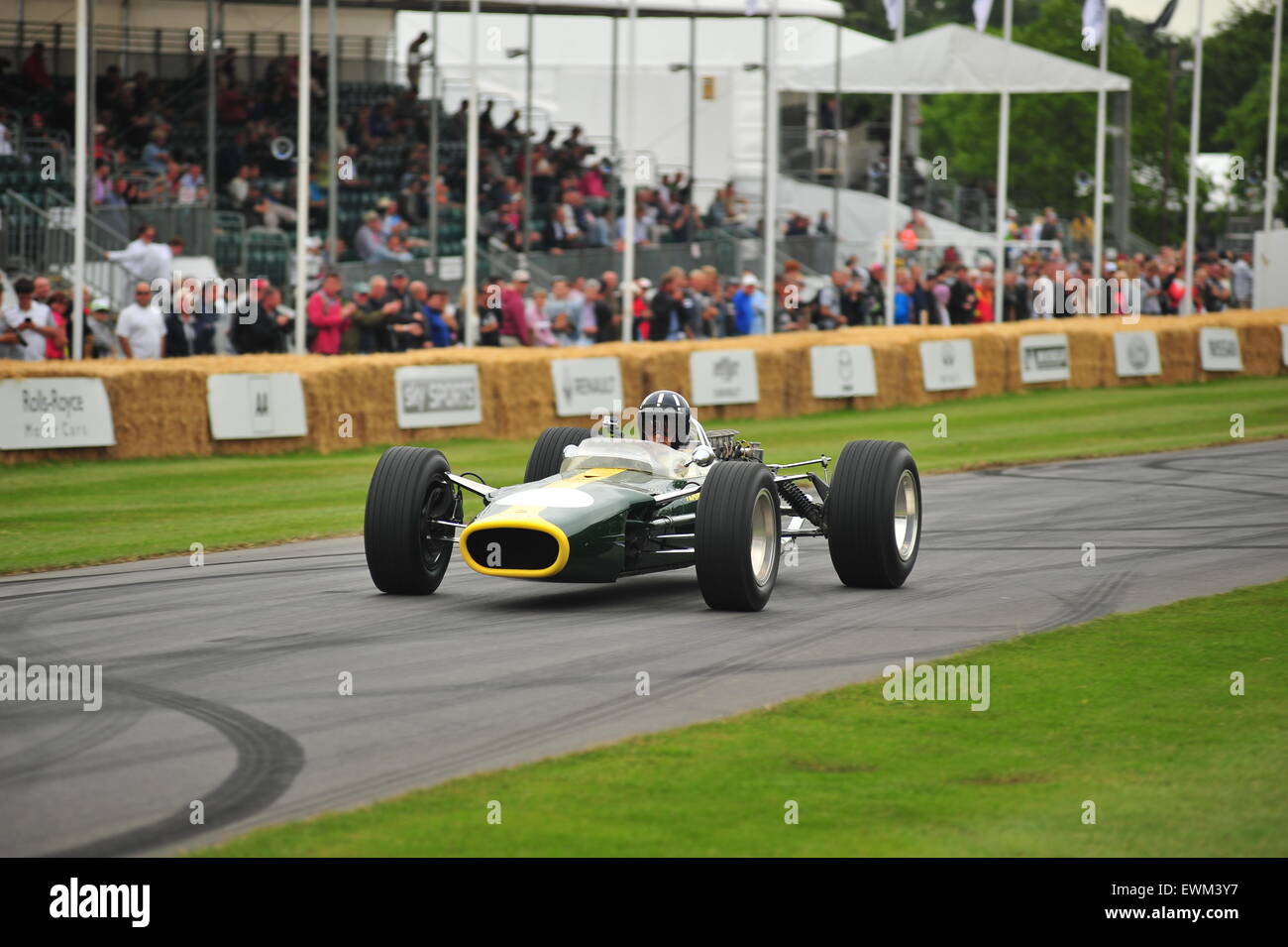 Damon Hill in a Lotus 49 driven by his father at the Goodwood Festival of Speed. Racing drivers, celebrities and thousands of members of the public attended the Goodwood Festival of Speed to see modern and old racing cars and bikes in action. Stock Photo