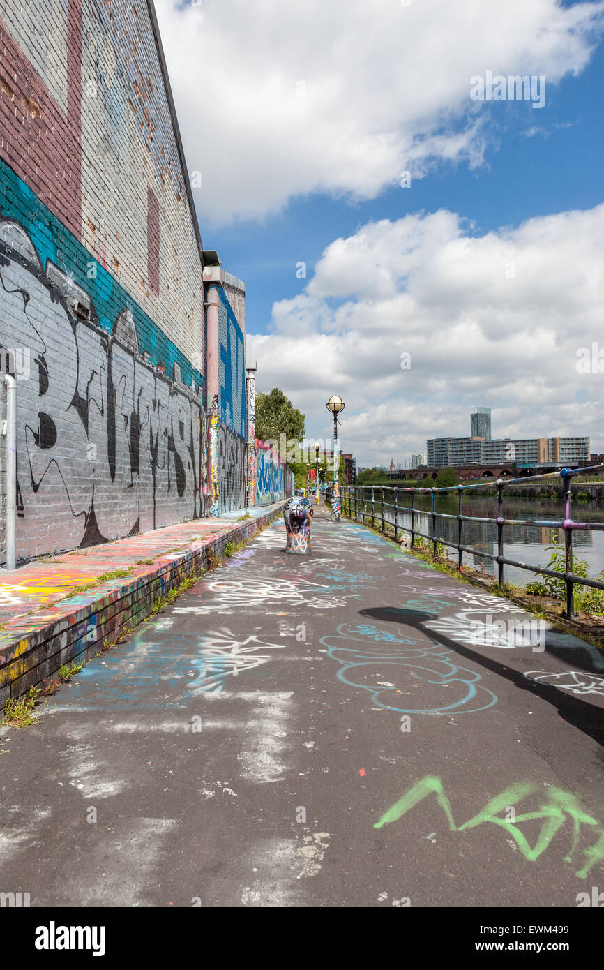 Empty urban graffitied scene along Manchester Ship Canal with diminishing perspective. Stock Photo