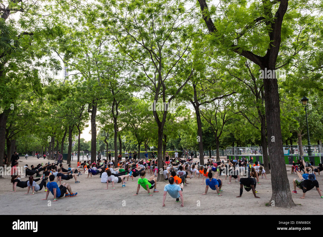 A large exercise class is held in the Champ de Mars park near the Eiffel Tower in Paris. Stock Photo