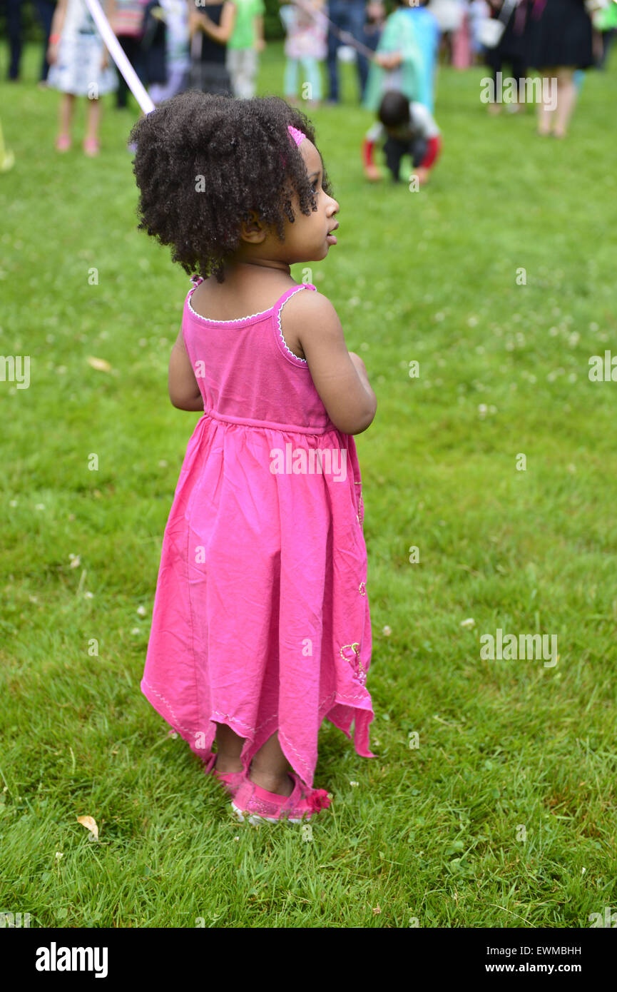 Old Westbury, New York, USA. 28th June, 2015. NYLAH JEANTY, 2 1/2 years old, of Franklin Square, is dancing around the Maypole, as Lori Belilove & The Isadora Duncan Dance Company, dressed in Renasissance themed tunics, give dancing lessons to children throughout the gardens, and then perform at historic Old Westbury Gardens, a Long Island Gold Coast estate, for its Midsummer Night event. © Ann Parry/ZUMA Wire/Alamy Live News Stock Photo