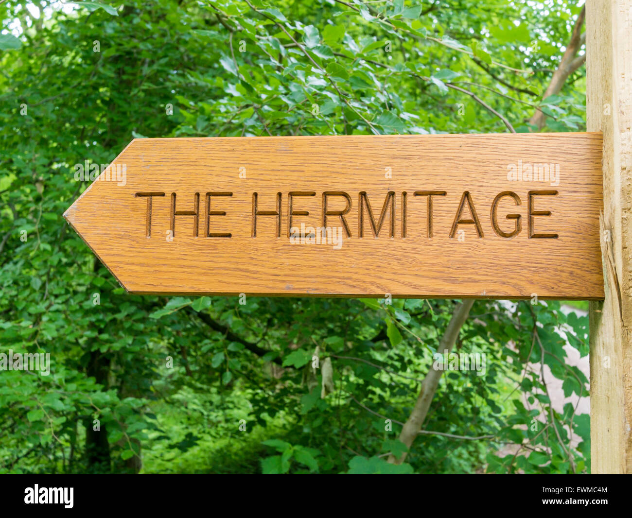 Wooden sign post to the Hermitage, a Hermits Cave, Sneaton Forest North Yorkshire Moors National Park Whitby North Yorkshire Stock Photo