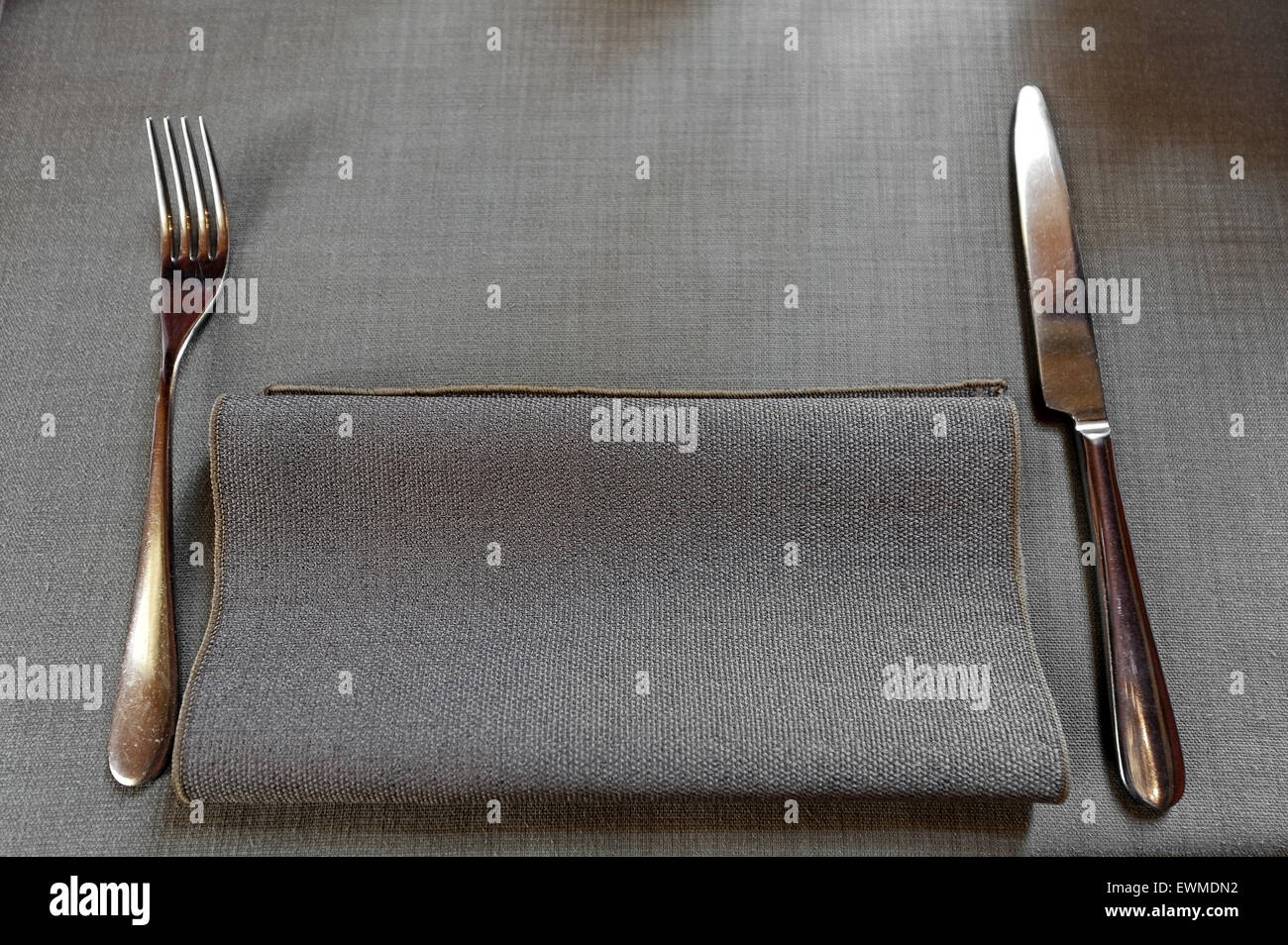 Dinner setting in a restaurant with a napkin, a fork and a knife Stock Photo