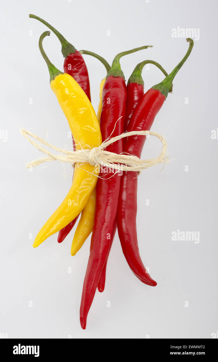 bunch of red and yellow chili peppers in light back Stock Photo - Alamy