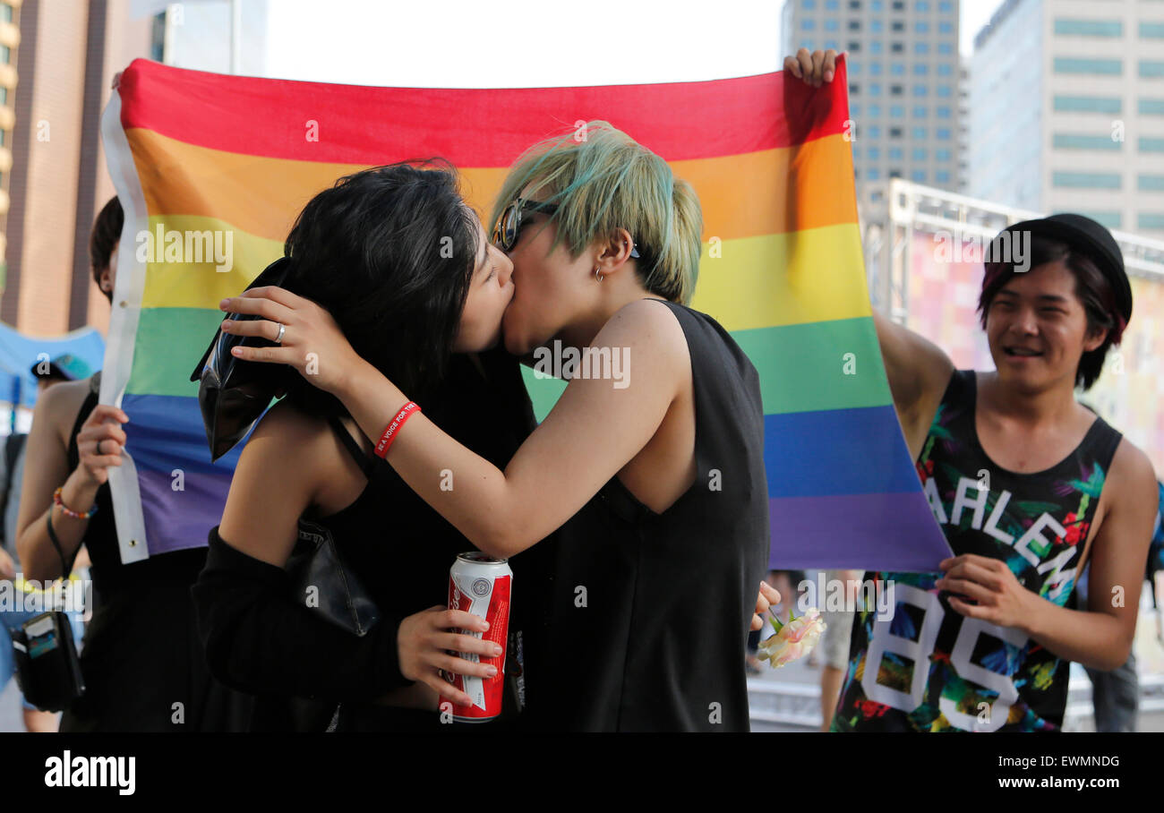 Seoul, South Korea. 28th June, 2015. Gay pride parade. A couple kiss during  the Korea Queer Festival, a gay pride parade in Seoul, South Korea as  conservative Christians (not seen in photo)