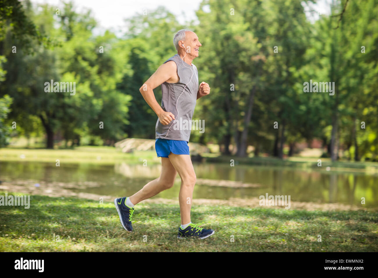 Profile shot of an active senior jogging in a park and listening to music on headphones Stock Photo