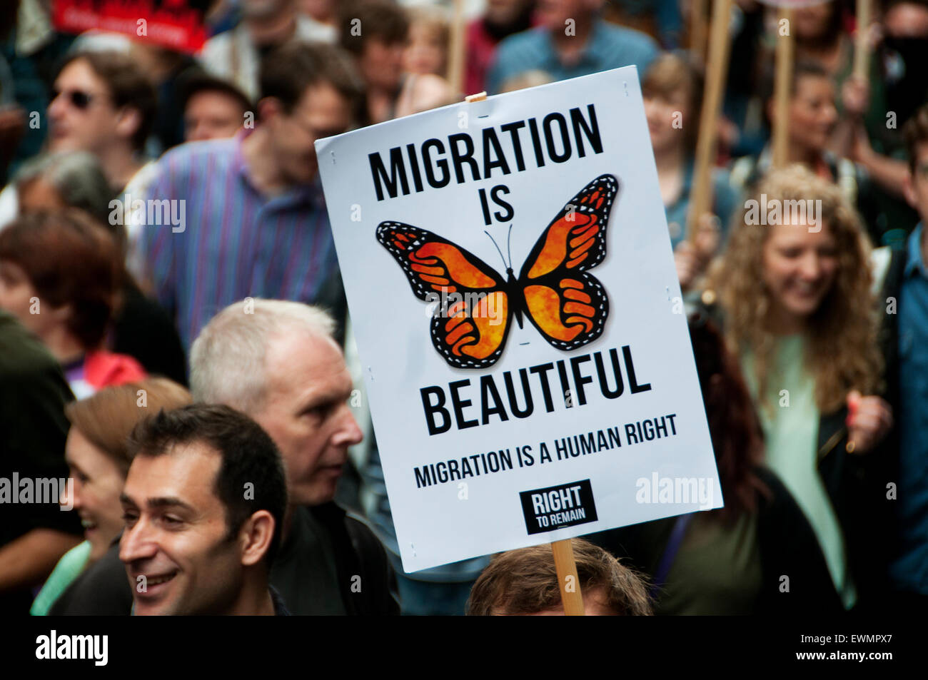 March against austerity, London June 20th 2015. A protester holds a placard saying 'Migration is beautiful'. Stock Photo