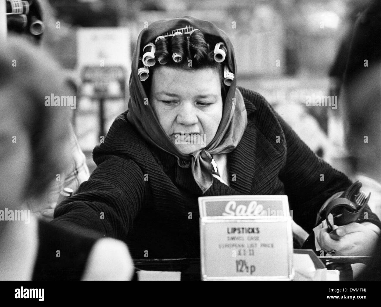 A woman wearing curlers in her hair enjoying shopping in the sales after Christmas. 31st December 1974. Stock Photo