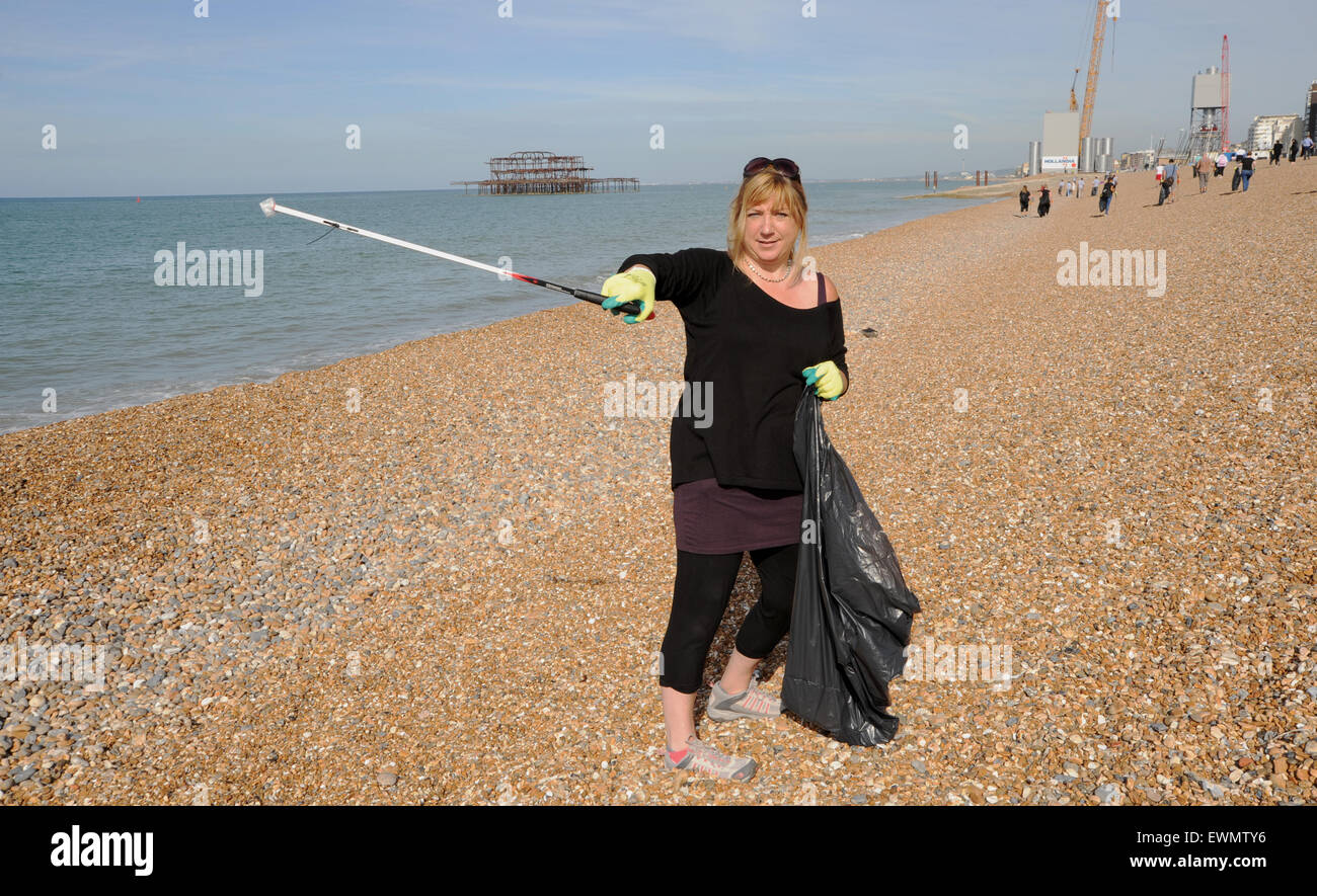 Woman litter picking on Brighton beach UK Stock Photo Alamy