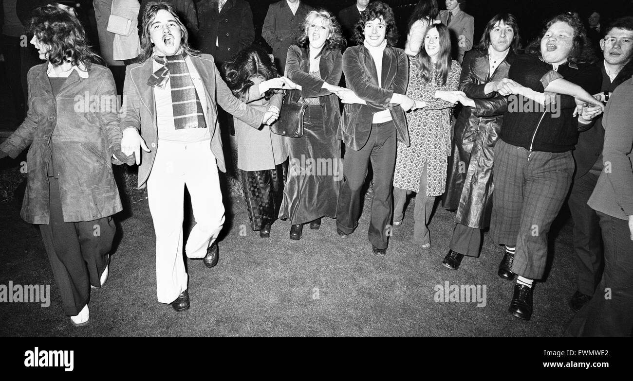 New Year Revellers seeing in 1973 in Centenary Square Birmingham sing Auld Lang Syne. 31st December 1972 Stock Photo