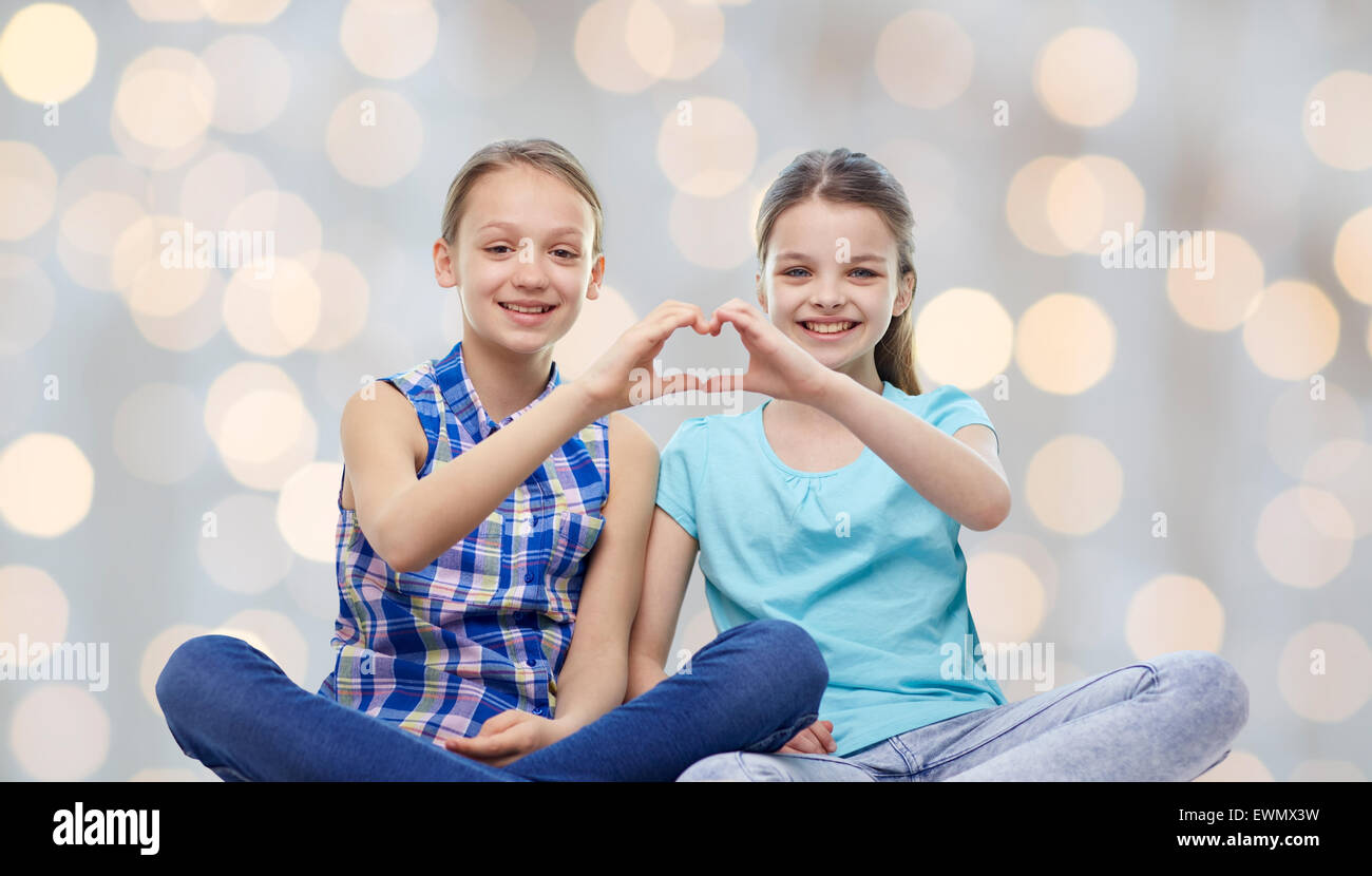 happy little girls showing heart shape hand sign Stock Photo