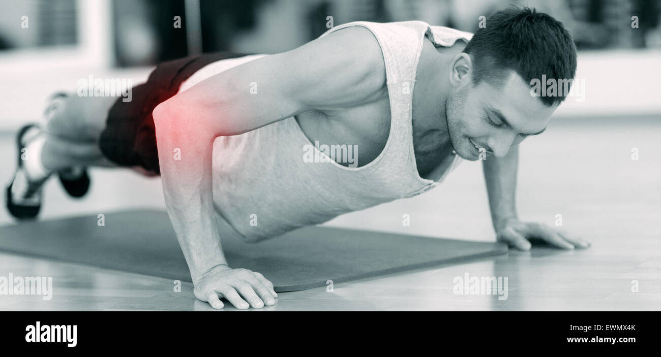 smiling man doing push-ups in gym Stock Photo