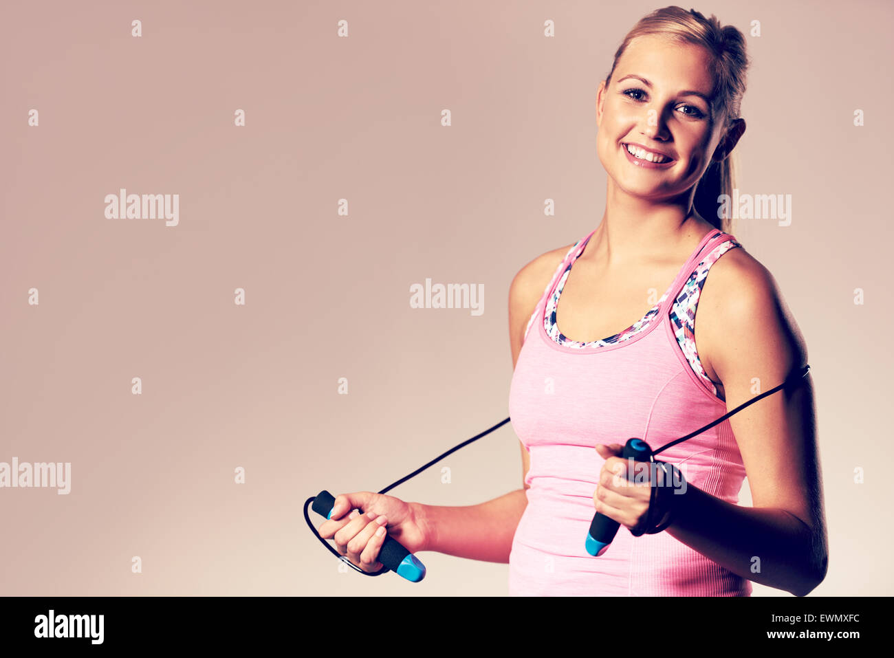 Beautiful Focused Woman In Sports Bra And White Shorts Using Headphones And  Blue Skipping Rope On Concrete Background Stock Photo, Picture and Royalty  Free Image. Image 181286831.