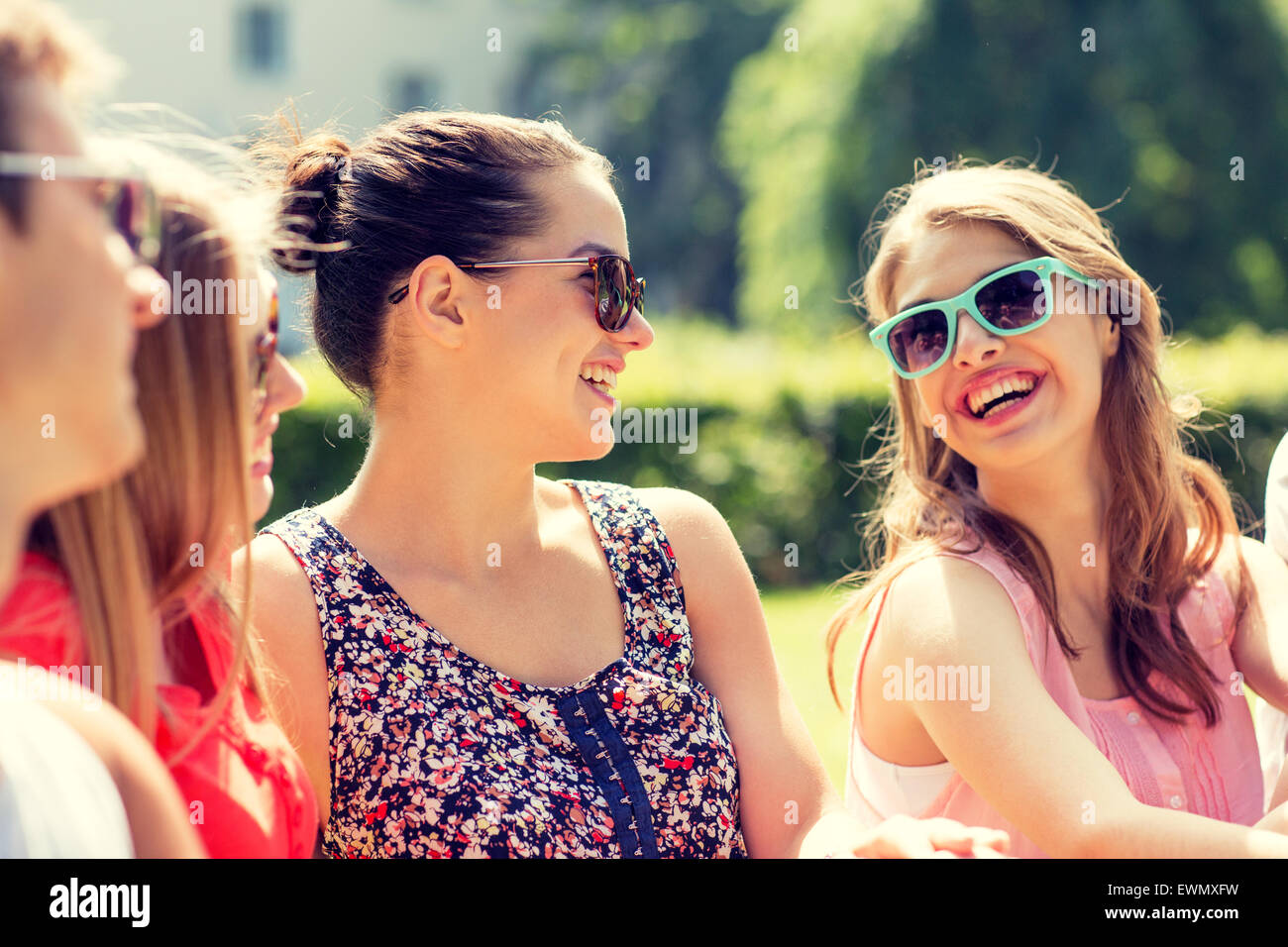 group of smiling friends outdoors sitting in park Stock Photo - Alamy