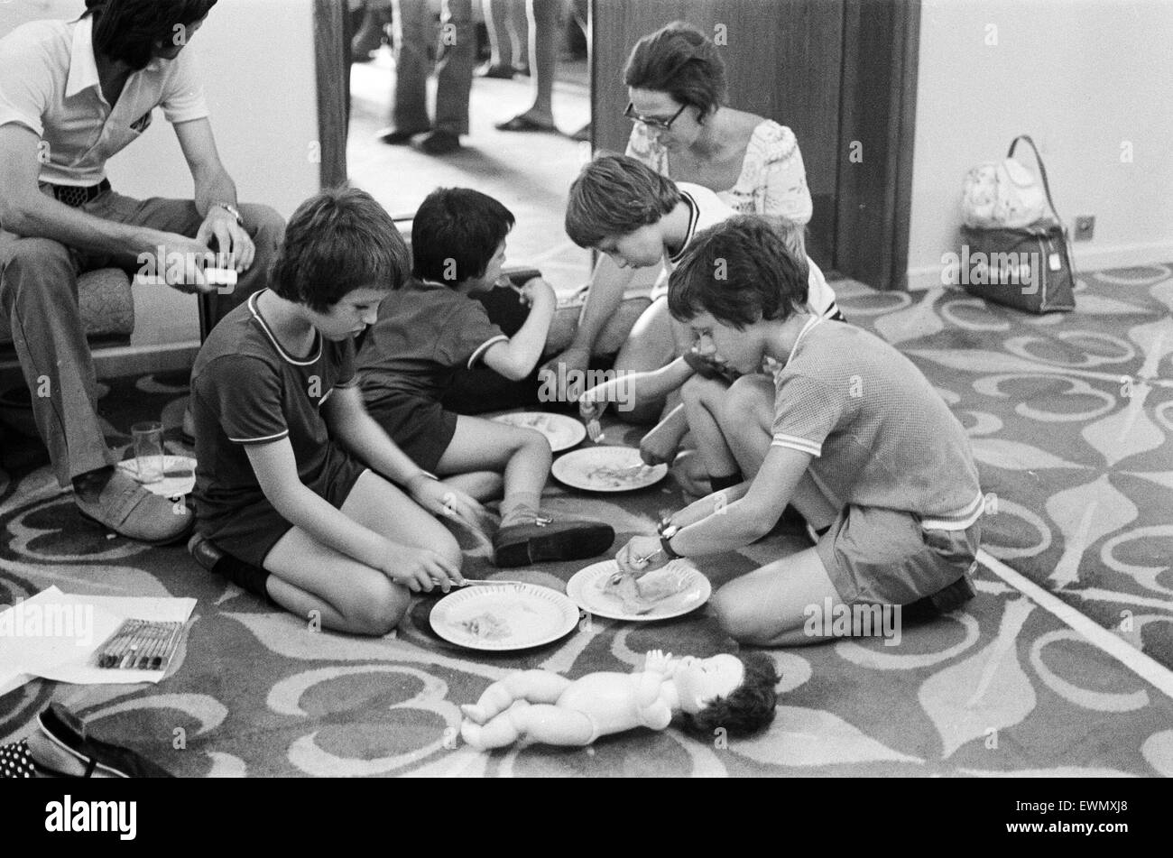 The Turkish invasion of Cyprus. Four boys squat on the floor at the Ledra Palace Hotel to eat a makeshift meal while their mother supervises the operation. The Ledra Palace Hotel became the centre of fighting with the Greek Cypriot soldiers keeping reside Stock Photo