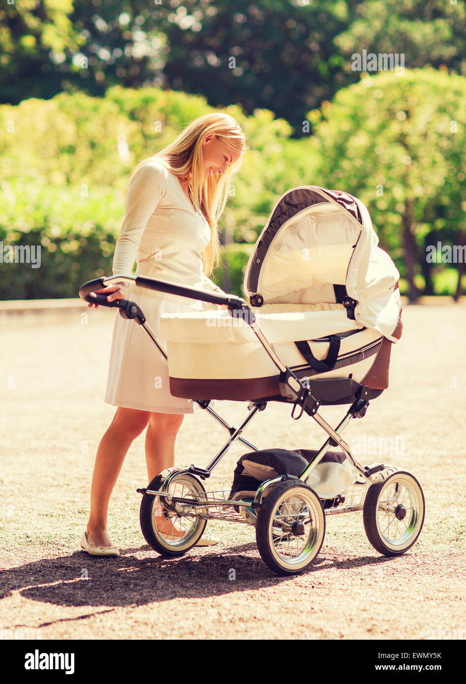 happy mother with stroller in park Stock Photo