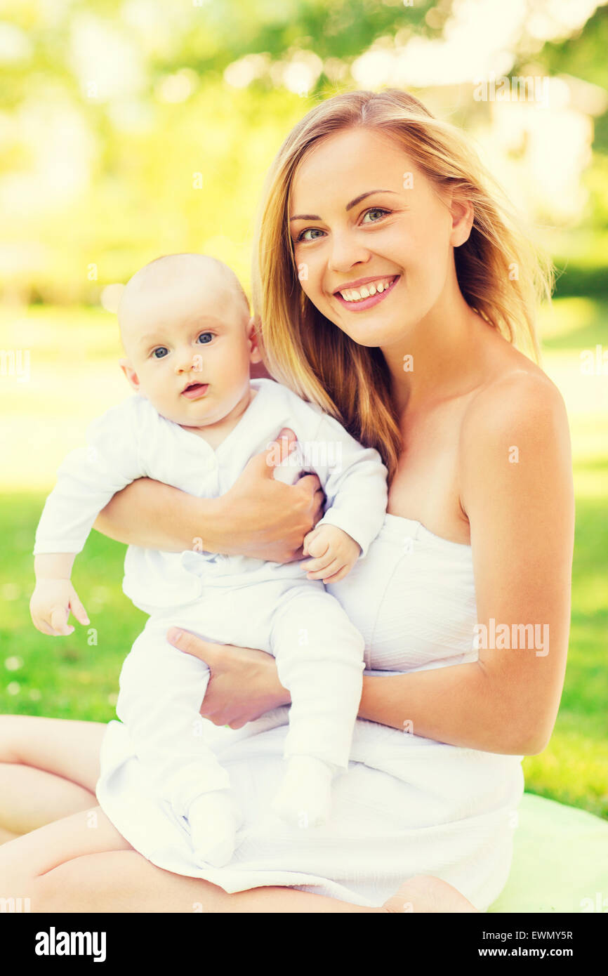 happy mother with little baby sitting on blanket Stock Photo