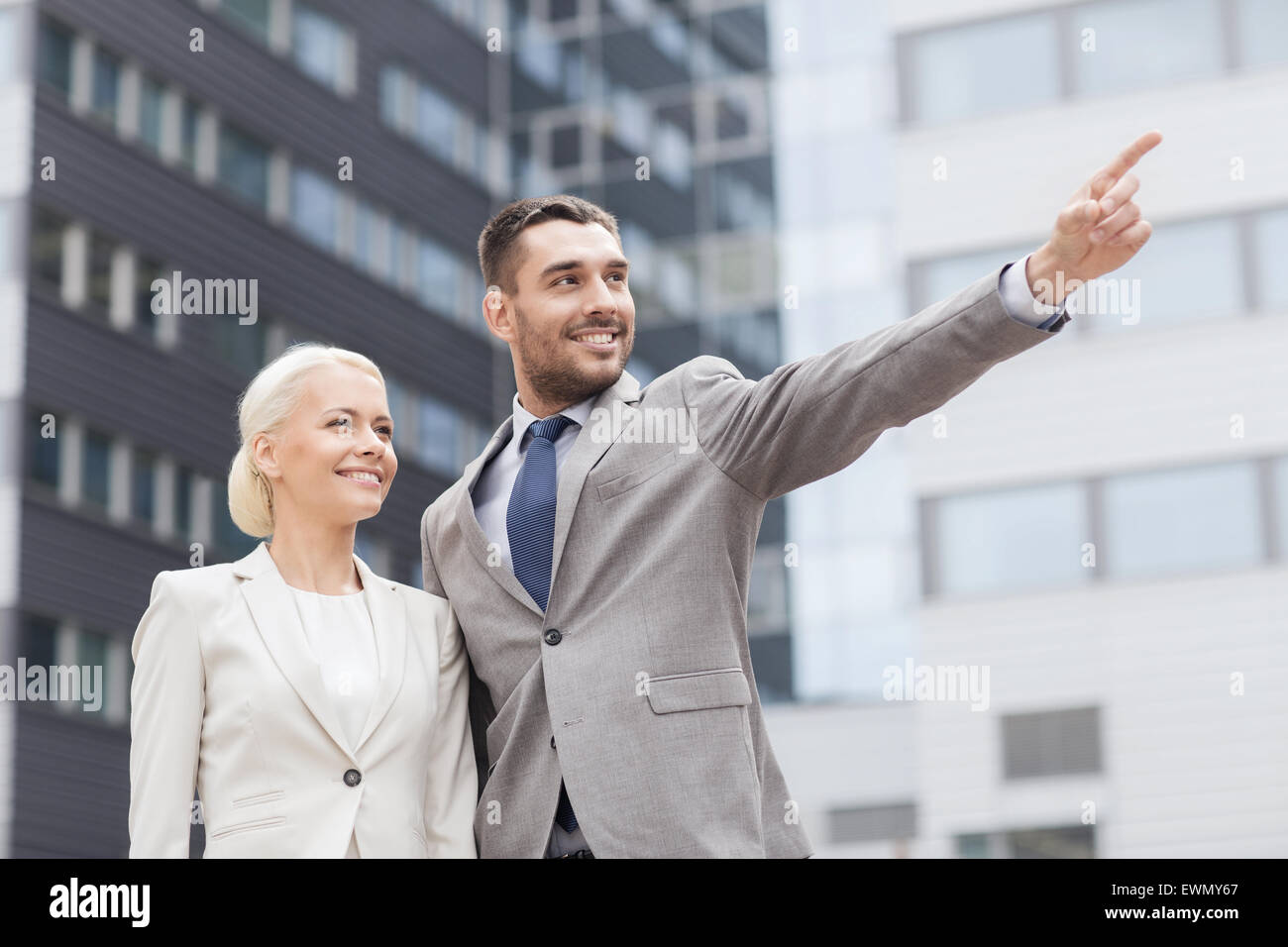 smiling businessmen standing over office building Stock Photo - Alamy