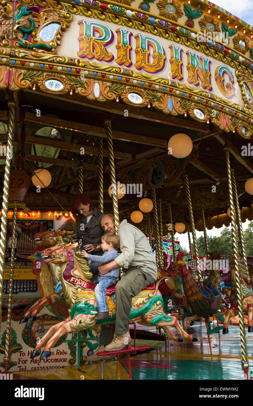UK, England, Cheshire, Chelford, Astle Park Traction Engine Rally, grandfather and grandson on traditional carousel Stock Photo