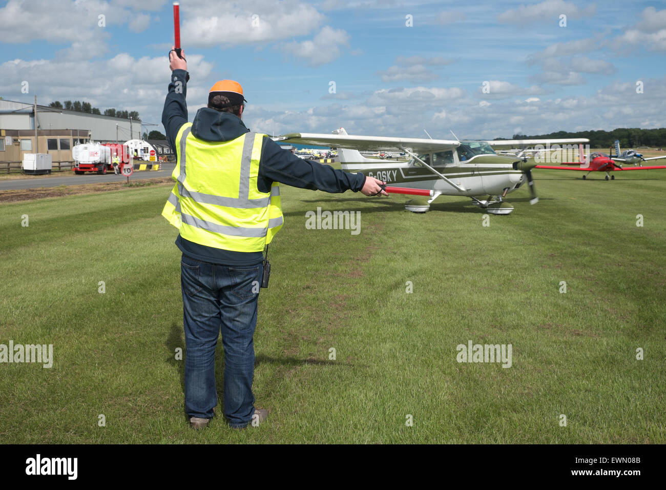 Aircraft marshaller directs a Cessna 172 light aircraft to turn at a