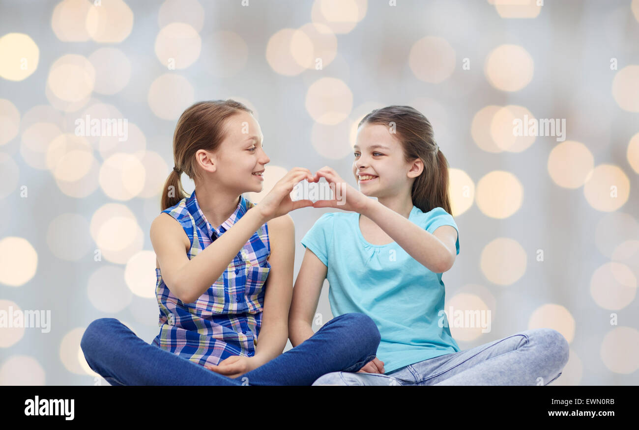 happy little girls showing heart shape hand sign Stock Photo