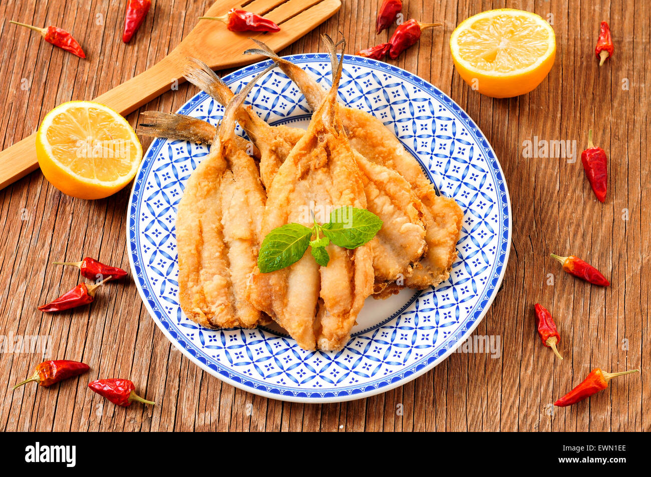 closeup of a plate with spanish boquerones fritos, battered and fried anchovies typical in Spain, on a rustic wooden table Stock Photo