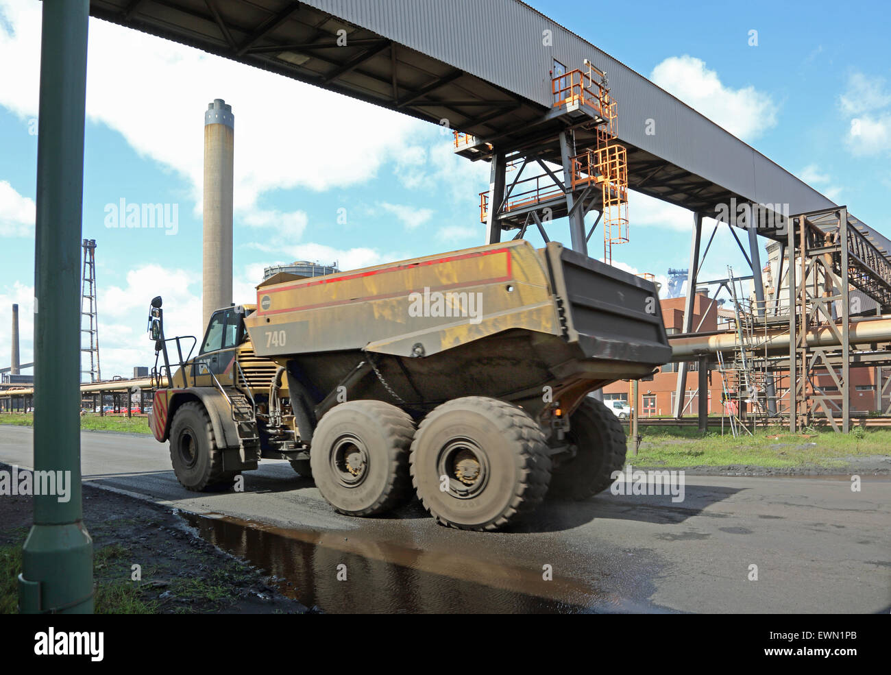 A specialist truck carries waste material beneath a conveyor gantry at the newly reopened Redcar Steel works, UK Stock Photo
