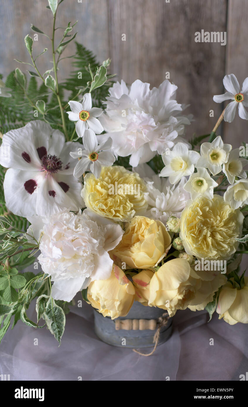 Bouquet with Rosa Graham Thomas and Rosa Port Sunlight, yellow David Austin roses, with Narcissus Poeticus var. recurvus and white peonies Stock Photo