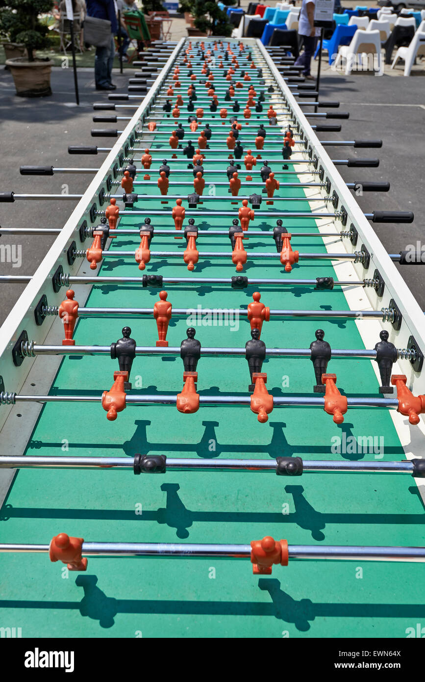 A huge table foosball allows twenty players have fun. In the background