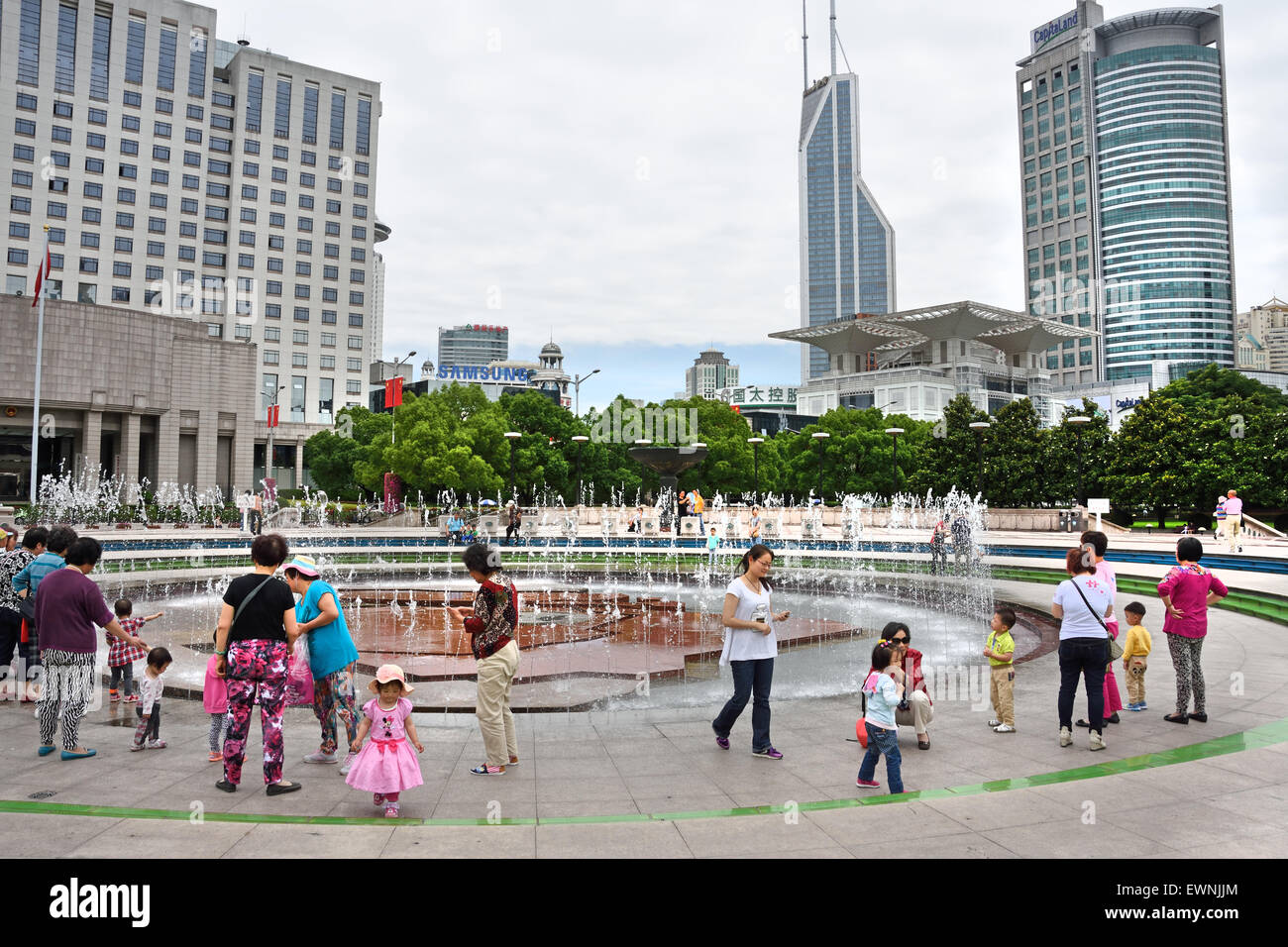 Fountain with people and children on People's Square Municipal Government Building Shanghai Municipality China skyline city Stock Photo