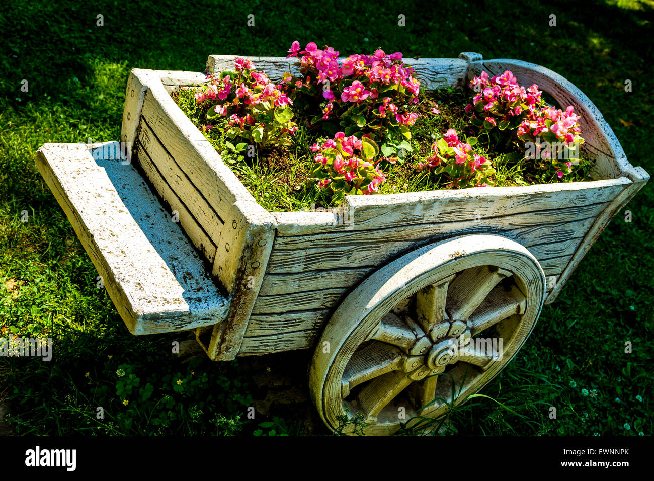 Vintage wooden wheelbarrow with flowers Stock Photo