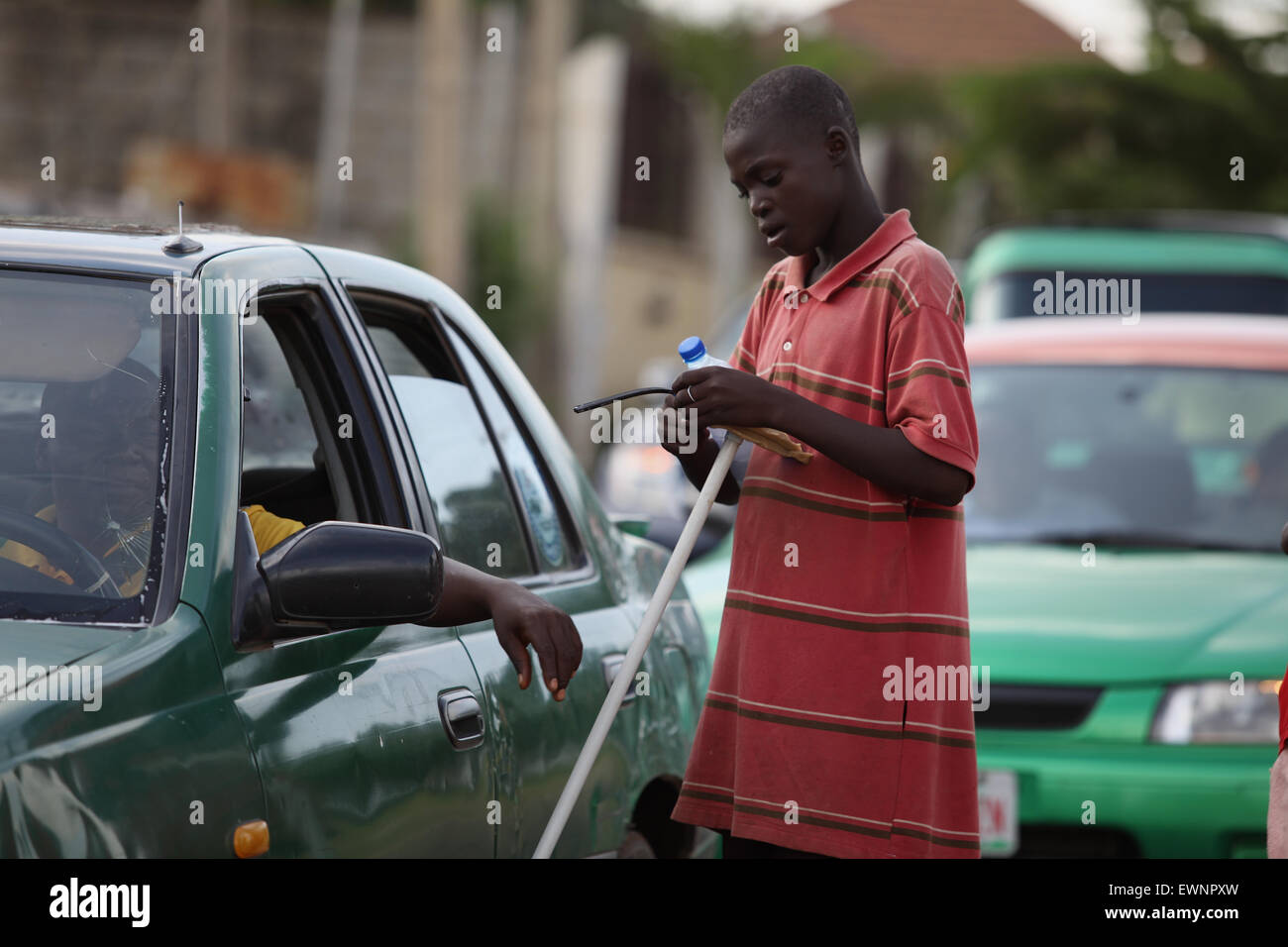 Teenager car wash in Nigeria particularly in Abuja it is phenomenal business in middle of the road. Stock Photo