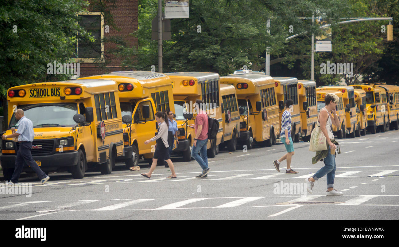 School buses waiting for the dismissal of their passengers are parked outside of an elementary school in the New York neighborhood of Chelsea on Friday, June 26, 2015. Today is the last day of school for New York public school students and is a half-day.  (© Richard B. Levine) Stock Photo