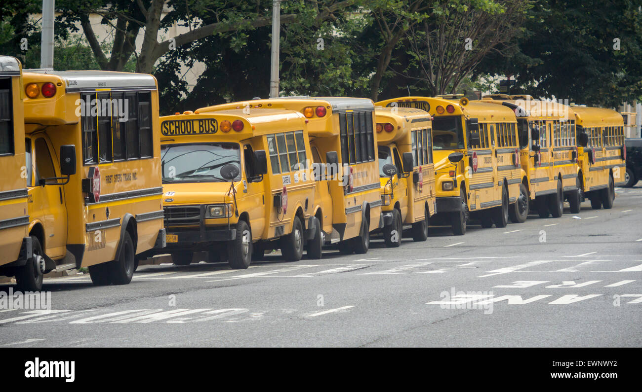 School buses waiting for the dismissal of their passengers are parked outside of an elementary school in the New York neighborhood of Chelsea on Friday, June 26, 2015. Today is the last day of school for New York public school students and is a half-day.  (© Richard B. Levine) Stock Photo